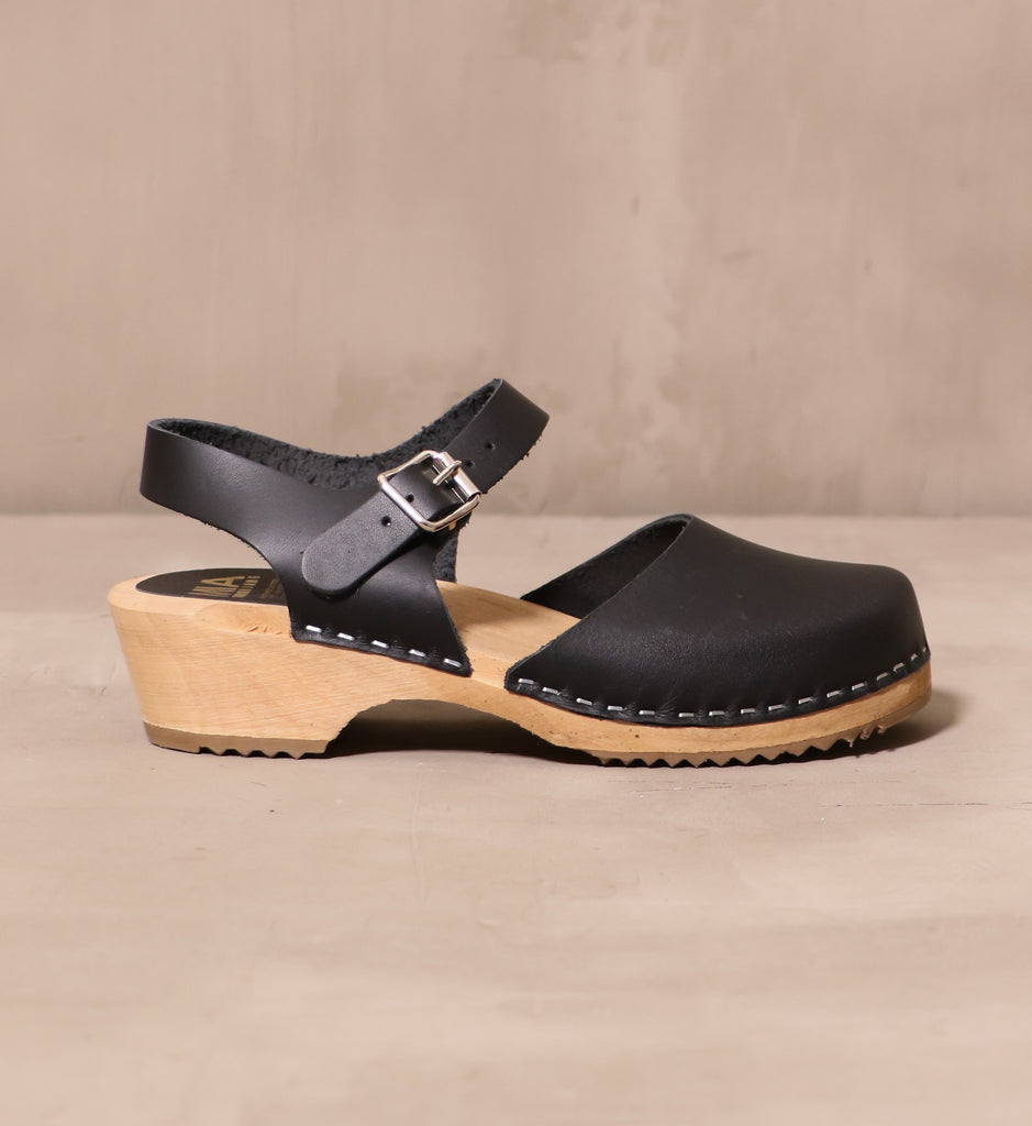 Black leather clog with a short heel.