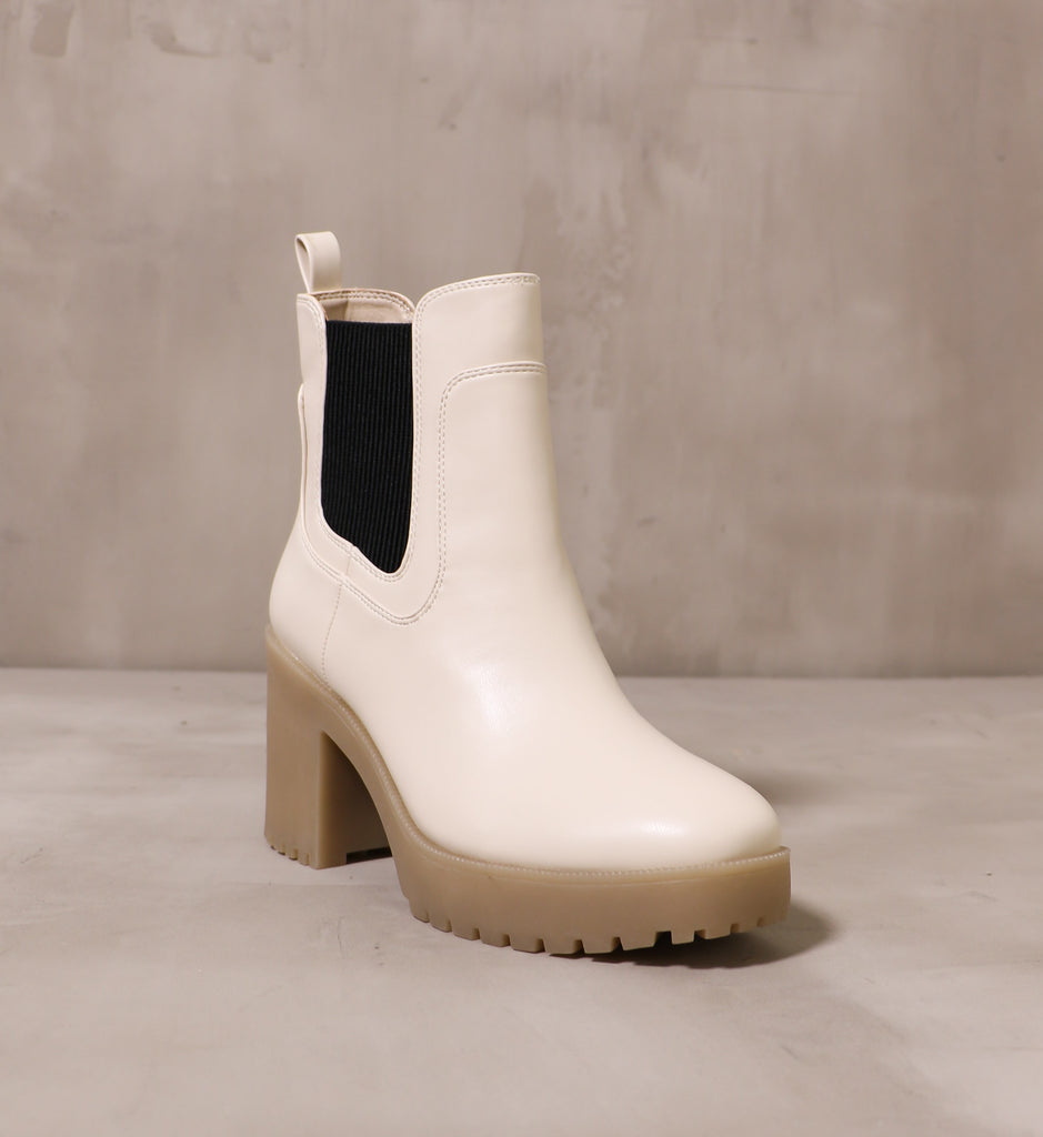 front of the round toe and off white leather upper on the chelsea you around boot on cement background