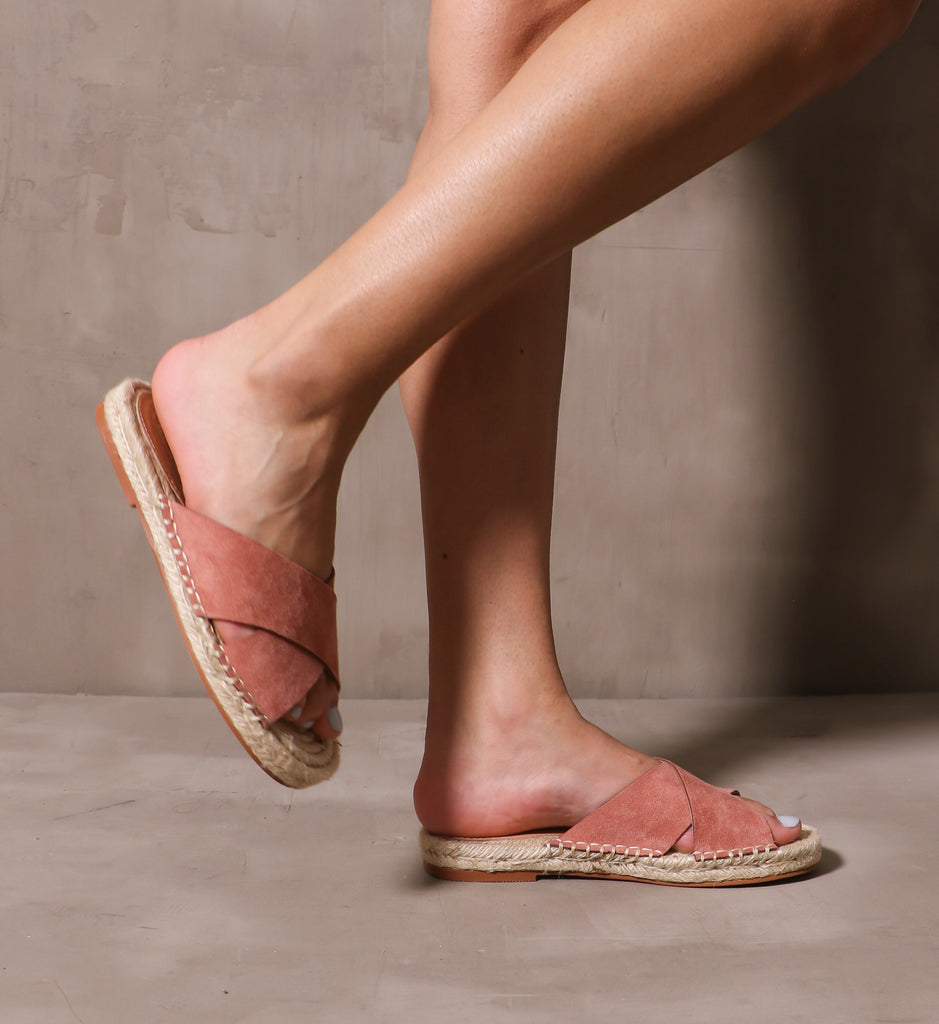 model walking in the rose pink espadrille you go with me slide sandals across cement background