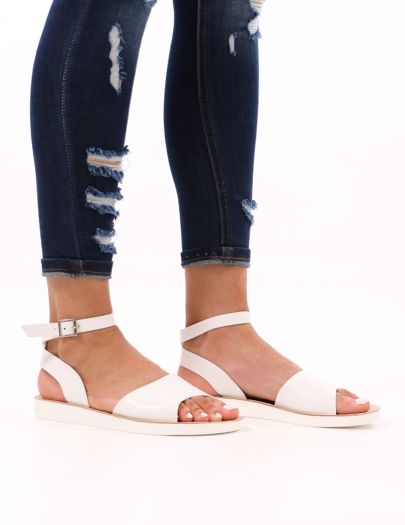 model standing in white long time no sea ankle strap sandal and distressed denim - elle bleu shoes