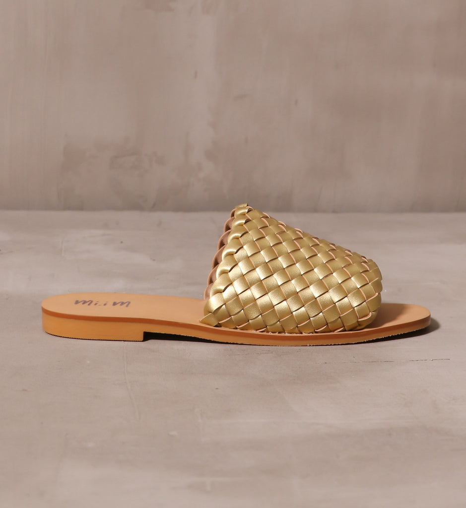 outer side of the woven one slide with gold woven thick strap upper across the bridge with tan sole