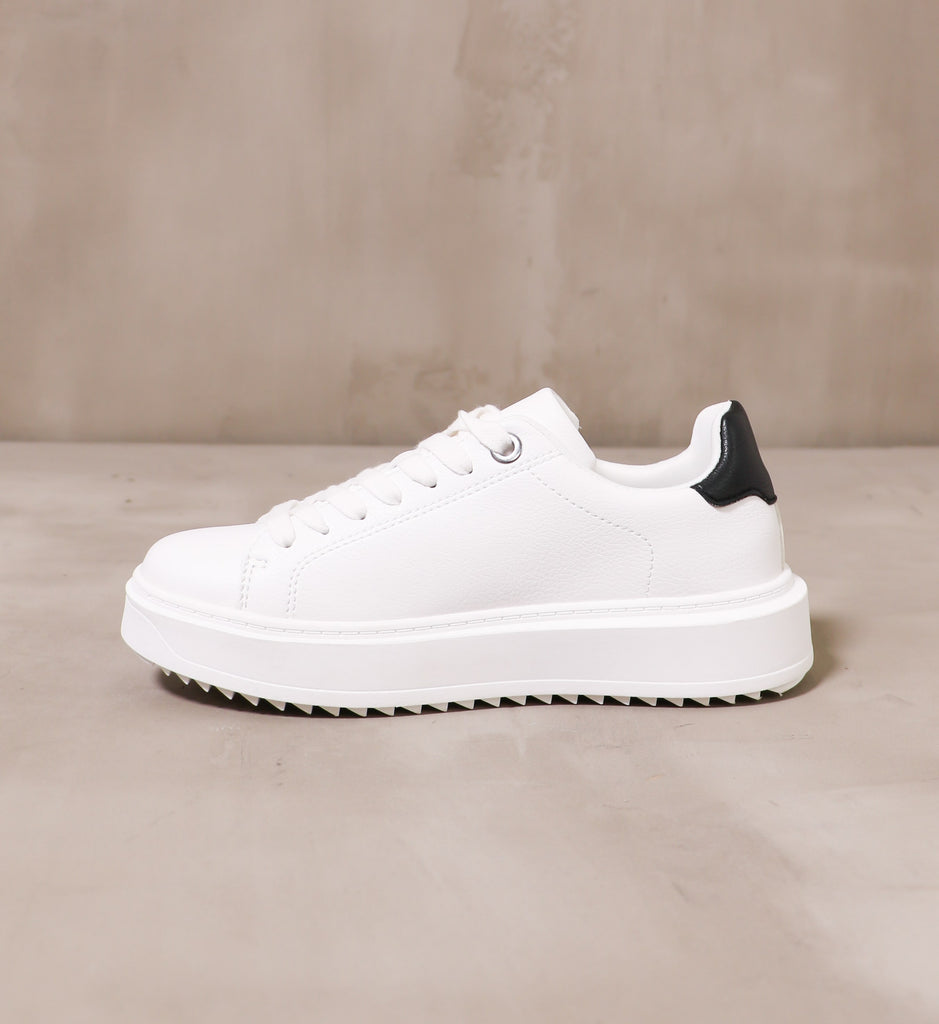 inner side of the white play the field sneaker with white laces and chunky rubber sole