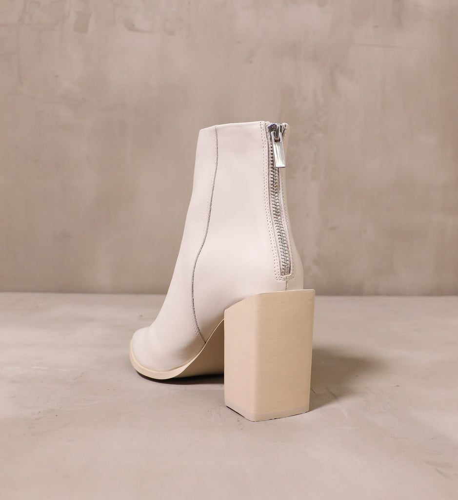 back of the she's so modern boot with silver back zipper and beige block wood heel