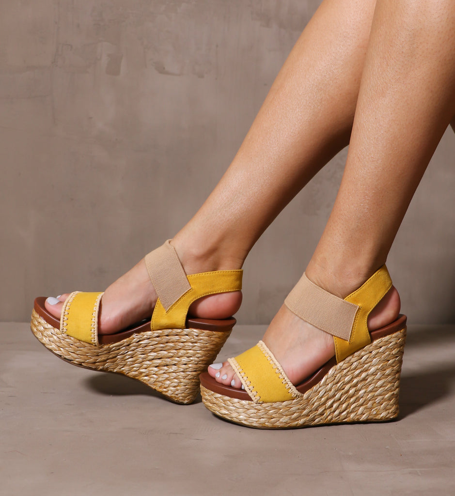 model wearing the yellow shore thing wedges on cement background