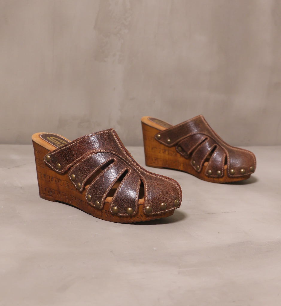 pair of tan brown leather sky's the rivet wedges on cement background