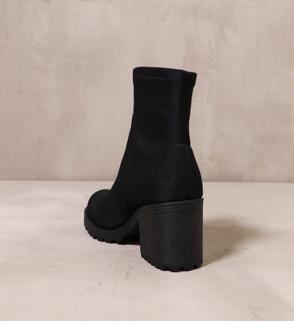 back of the chunky block heel on the stellar phenomena boot on cement background