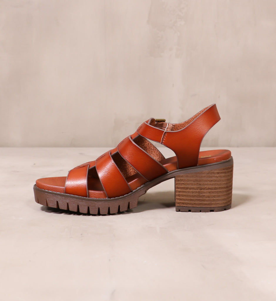 inner side of the chunky brown rubber tread and cognac leather cage upper on the strappy to cleat you sandal