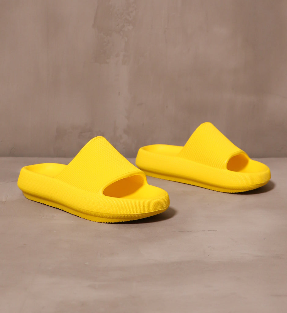 yellow mia late to the foam party slip on pool slides angled on cement background - elle bleu shoes