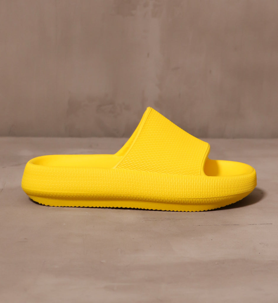 outer side of the yellow late to the foam party slide with open toe slip on design