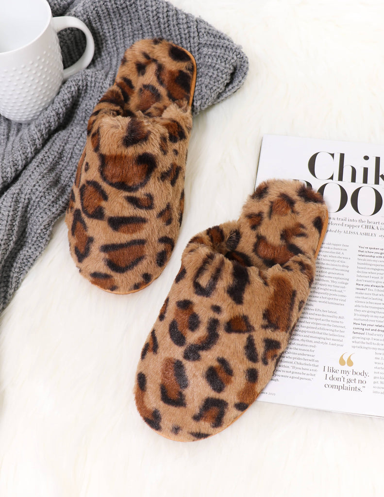 Leopard print elle bleu fuzzy wuzzy slippers on white fur rug with coffee mug