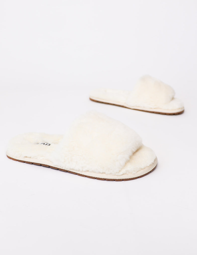 side view of the cream 'cozy fur you' slipper.