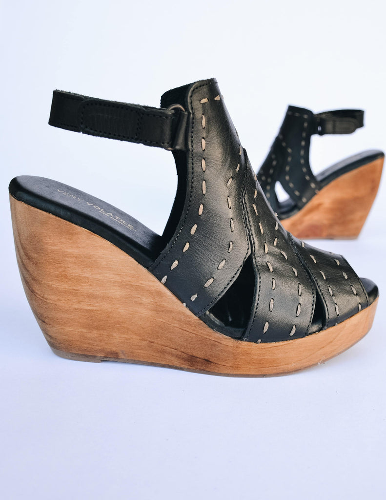 Side view of the bolanos black wedge with open toe and open back