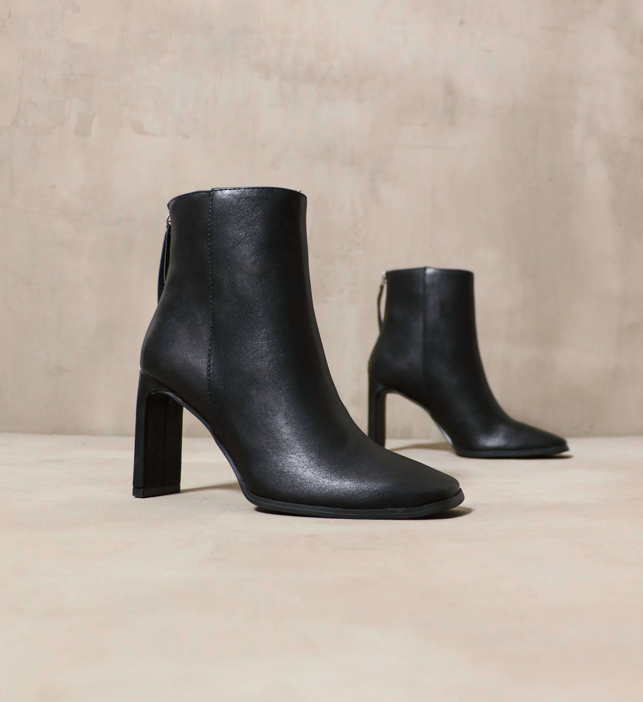 The Not the Basic Bootie in Black on a cement background - Elle Bleu 