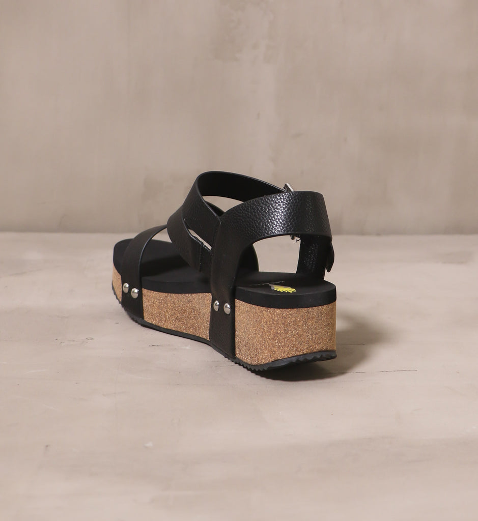 back of the all strapped in wedge with black leather straps and thick black insole