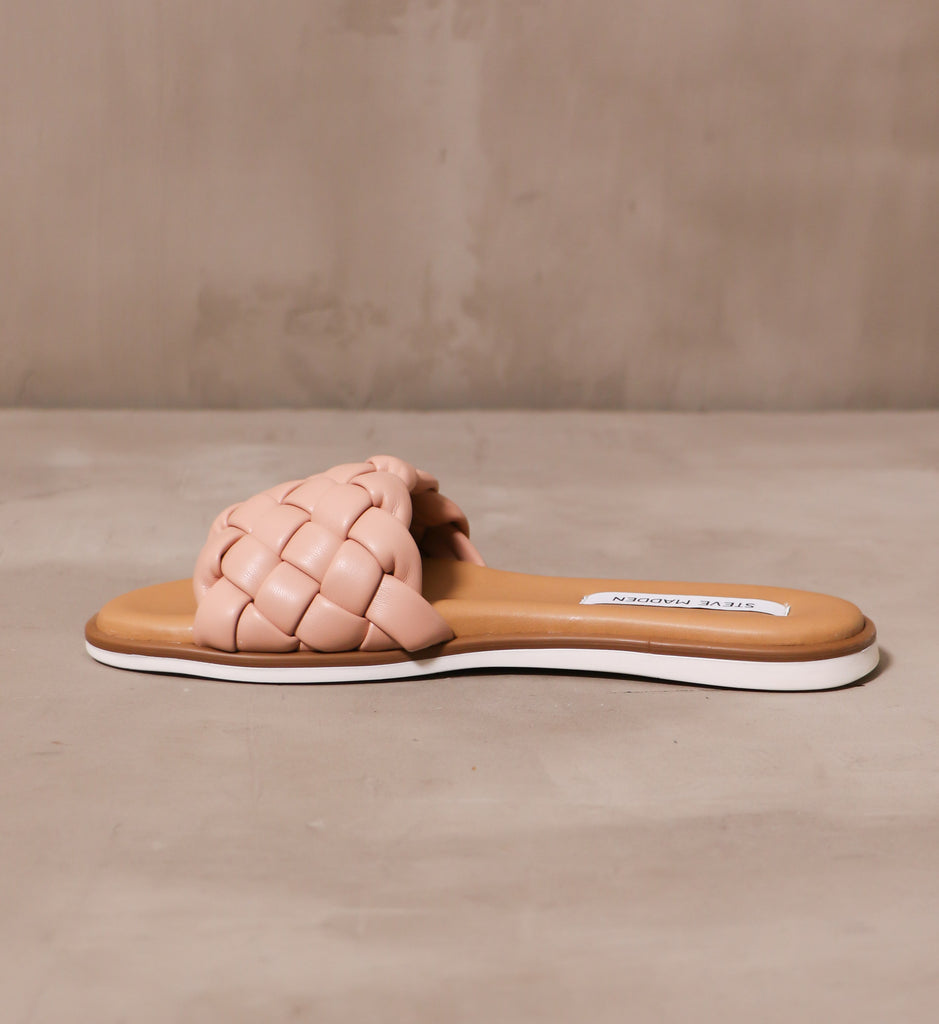 inner side of the pink braided blush crush slide sandal on cement background