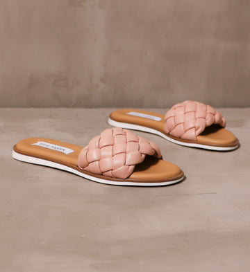 pair of tan insole and braided strap blush crush sandals angled on cement background