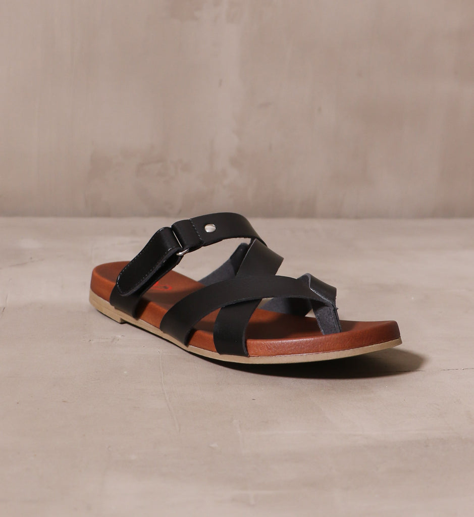 front of the black casually crossed sandal with brown insole and tan sole