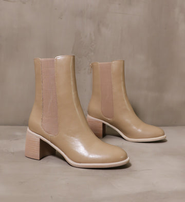 pair of latte consider it done leather boots angled on cement background