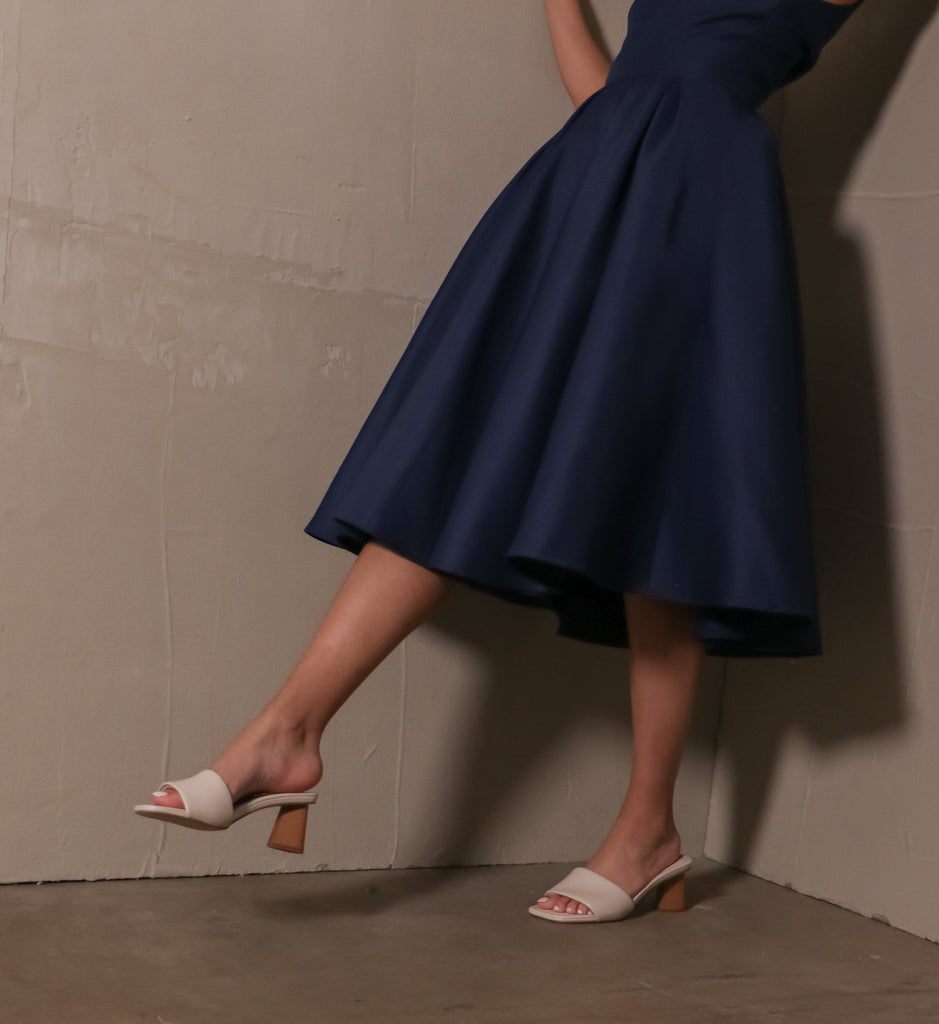model standing in the modern kinda gal heels wearing blue tea length dress