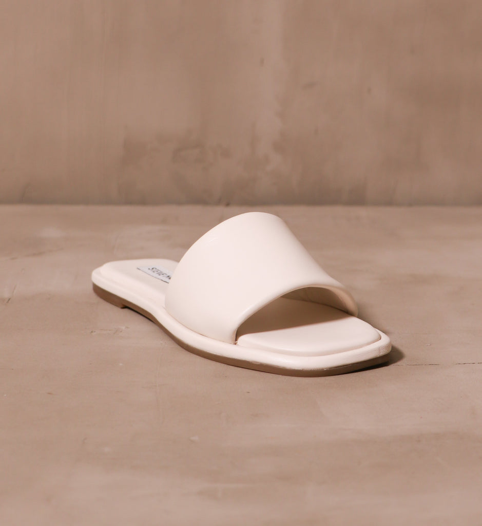 front of the square toe bed with open silhouette and cream strap connected to the cream insole