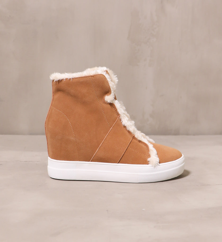 outer side of the tan suede fur wedge and fur all sneaker boot with chunky white rubber sole