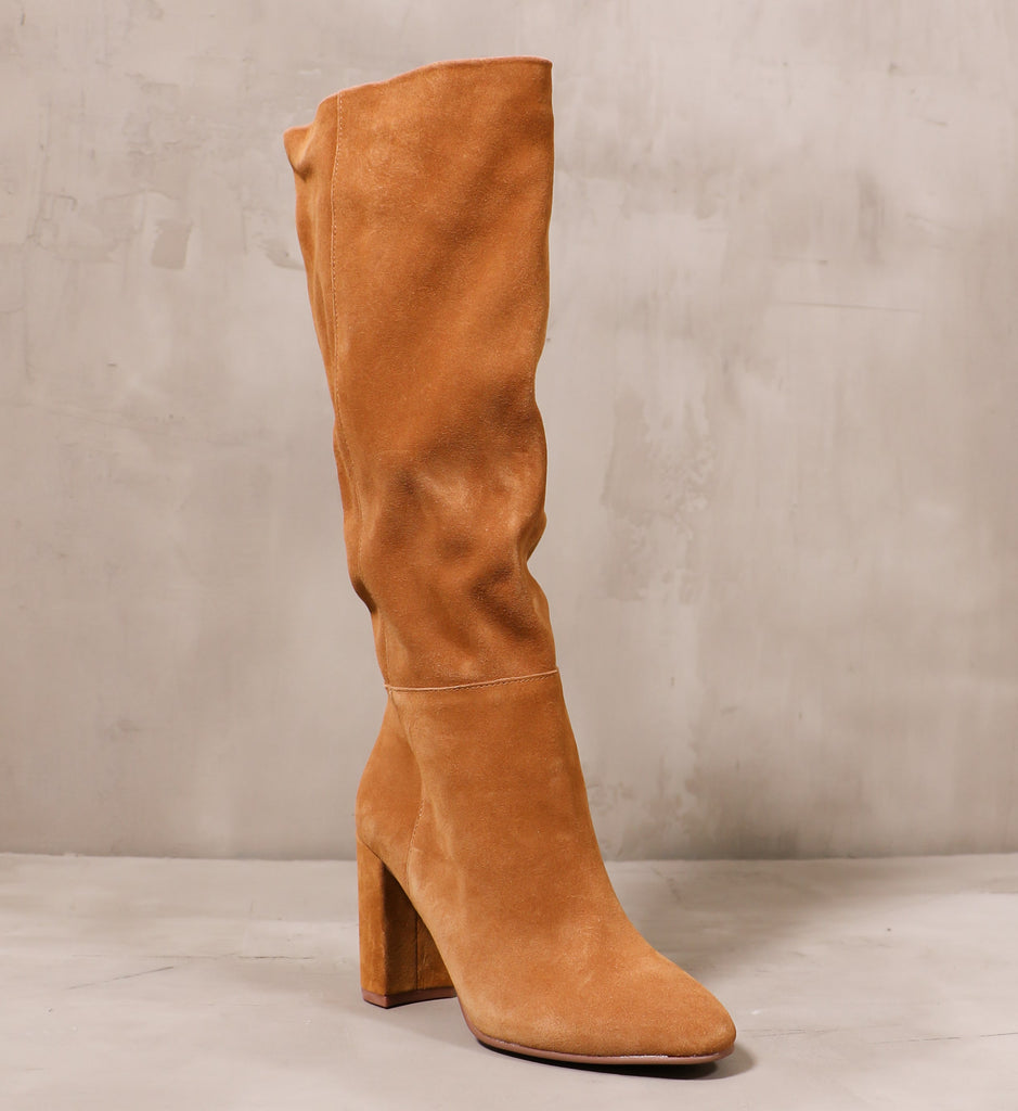 front of the golden hour boot with suede leather upper and block heel on cement background