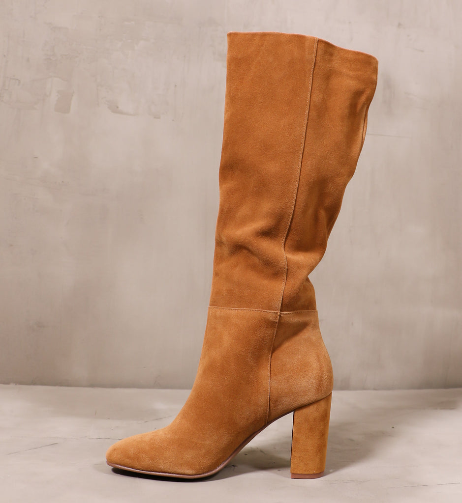 inner side of the honey brown golden hour boot with tall shaft and block heel sitting on cement background