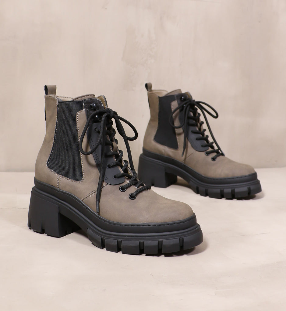 pair of black lug sole hike it or not boots angled on cement background