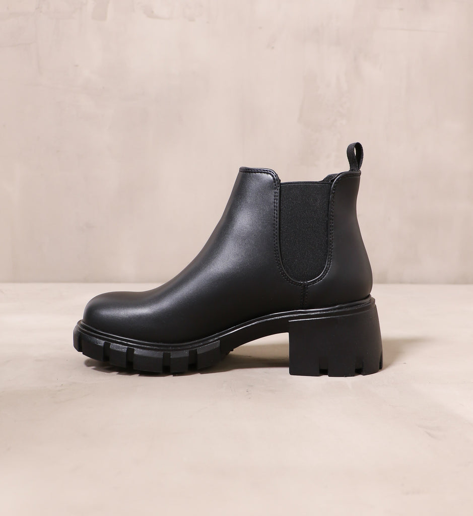inner side of the in a quandry boot with black leather upper and chunky rubber block heel and sole