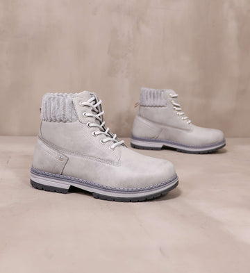 pair of grey in the forecast boots angled on cement background