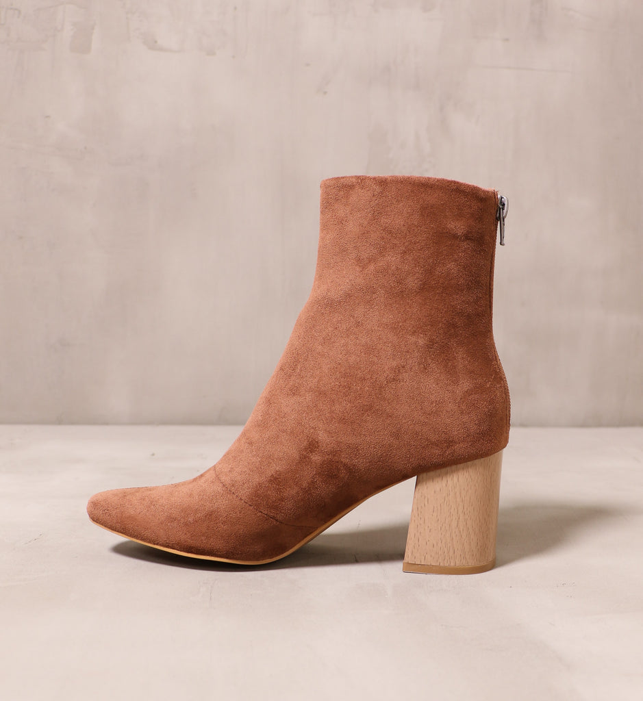 inner side of the chestnut brown keepin' it casual suede block heel bootie on cement background