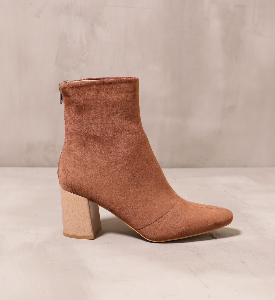 outer side of the chestnut brown keepin' it casual boot with wood block heel on cement background