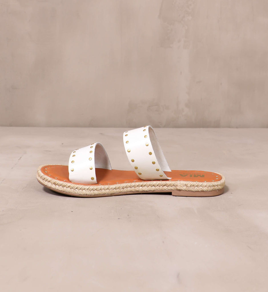inner side of the white straps and rope trim on the let the stud times roll sandal