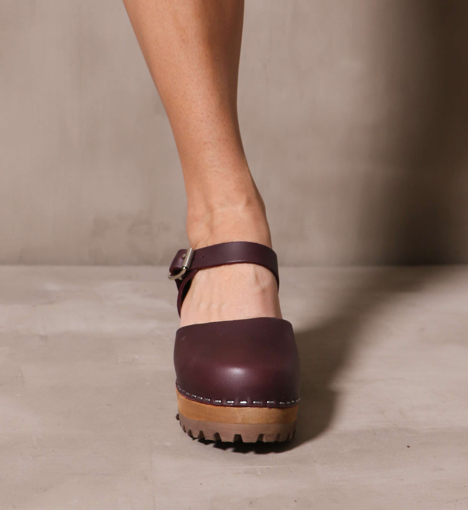 front of the round leather toe on the maroon wine abba swedish clog on cement background