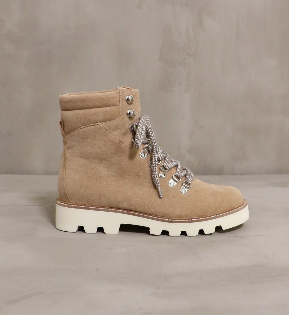 outer side of the neutral territory boot with cream chunky rubber sole on cement background