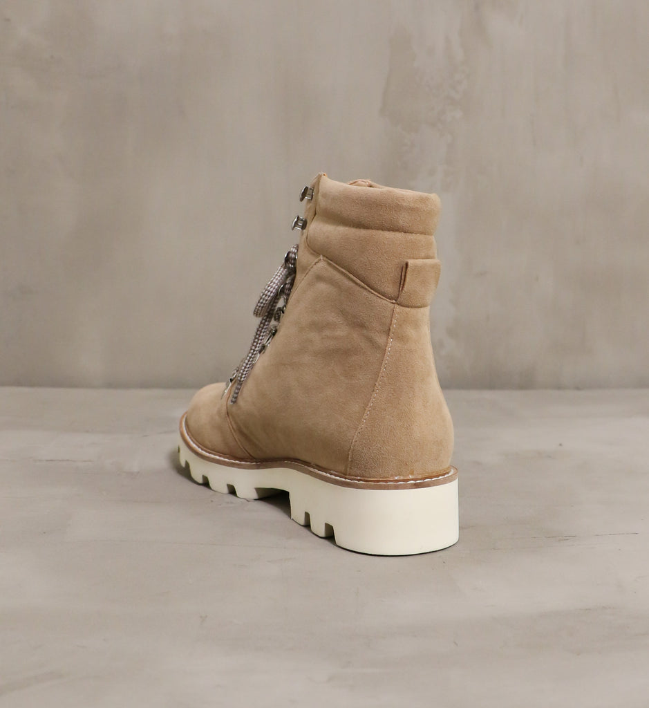 back of the neutral territory boot with cream rubber sole on cement background
