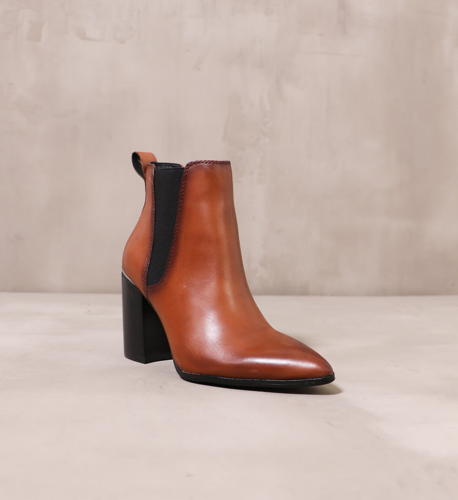 front of the pointed toe perfectly trimmed ankle boot with oil rubber leather upper and black elastic panel