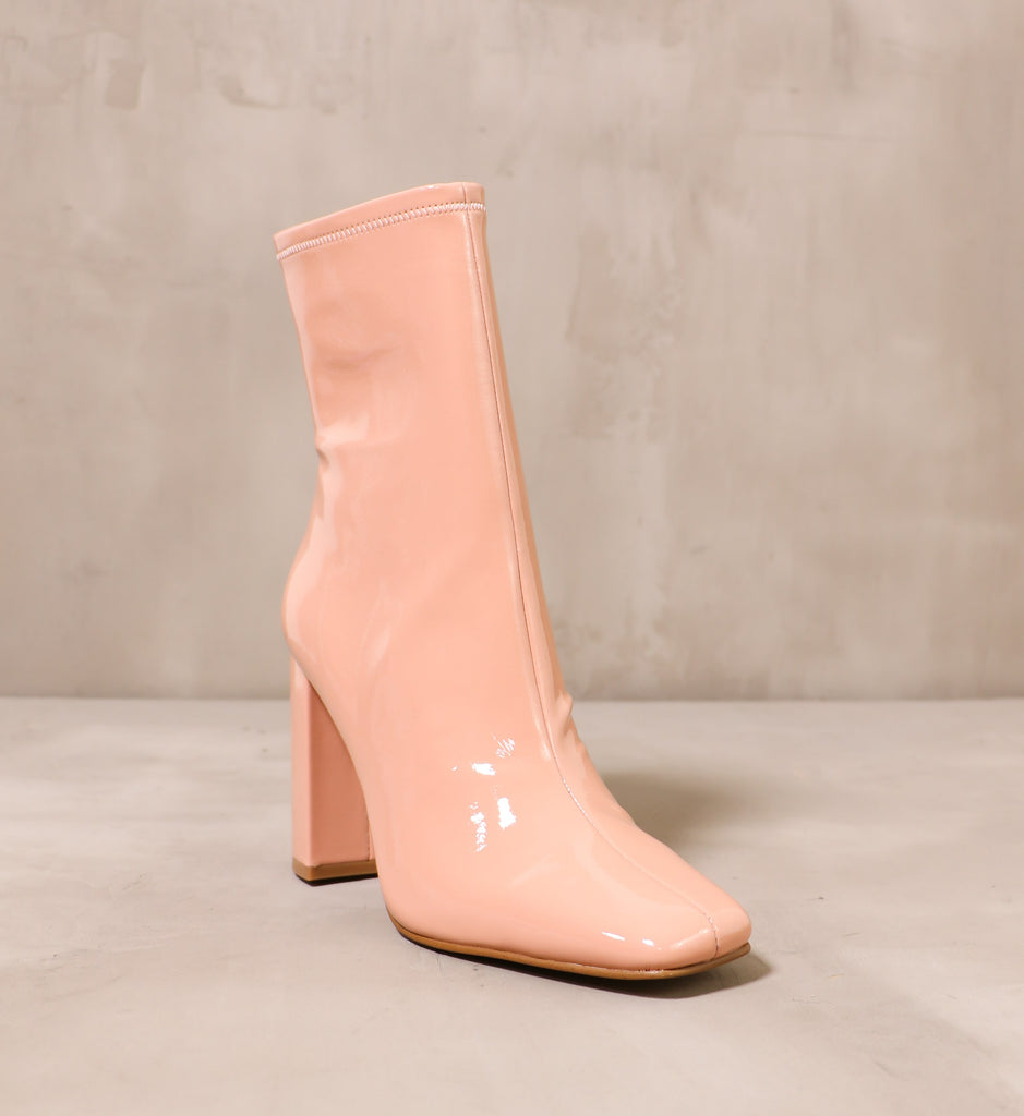 front of the square toe and shiny blush pink faux patent leather upper