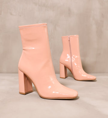 pair of blush pink big boots angled on cement background