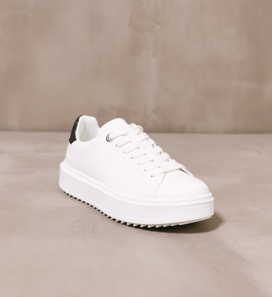 front of the round toe play the field sneaker with chunky white rubber tread and white laces