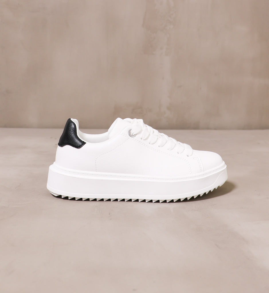 outer side of the white chunky sole and black leather heel detail on the play the field sneaker