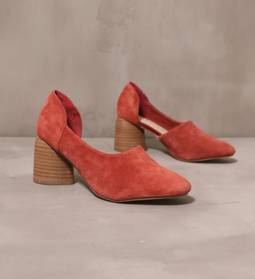 pair of rust retro romance suede heels on cement background
