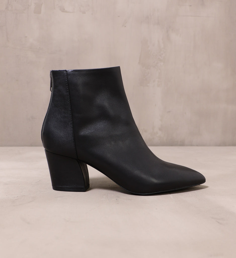 outer side of the black pointed toe leather simple explanation boot with leather wrapped block heel