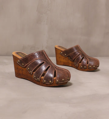 pair of tan brown leather sky's the rivet wedges on cement background
