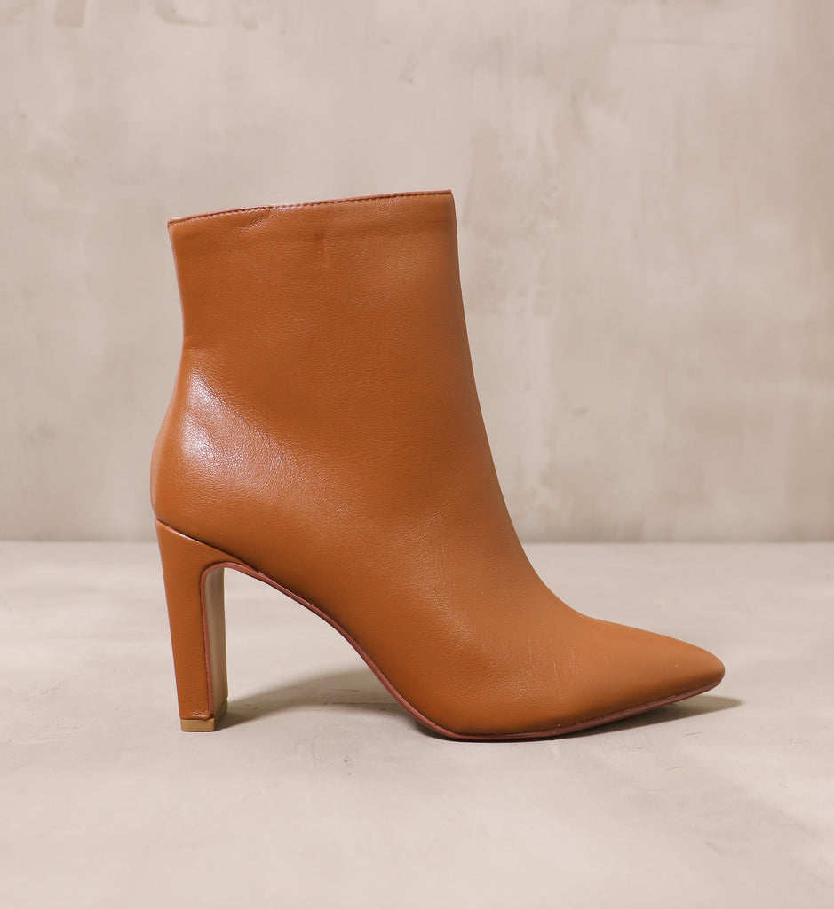 outer side of the sleek step ankle boot with brown tan leather upper and thin block heel