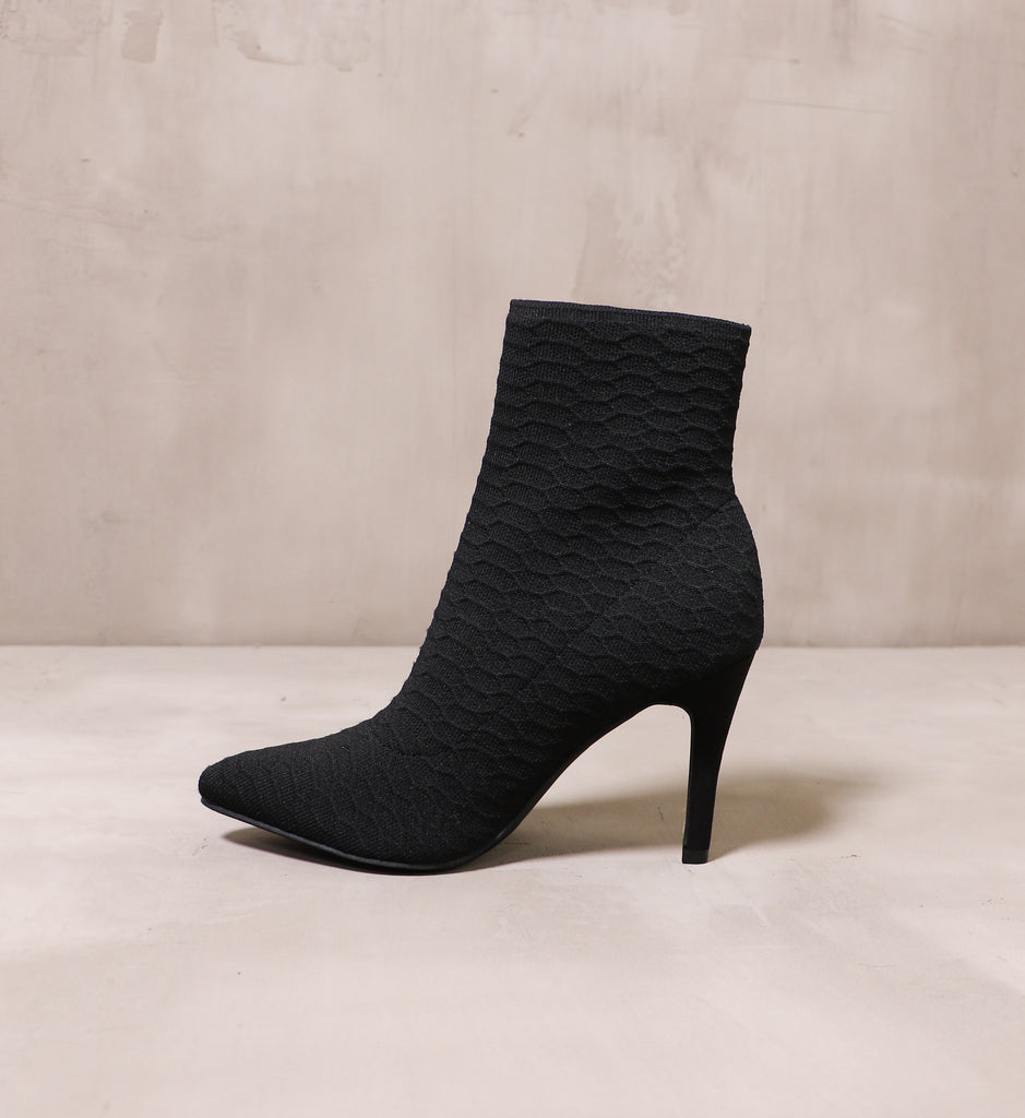 inner side of the black textured sock it to me bootie with stiletto heel