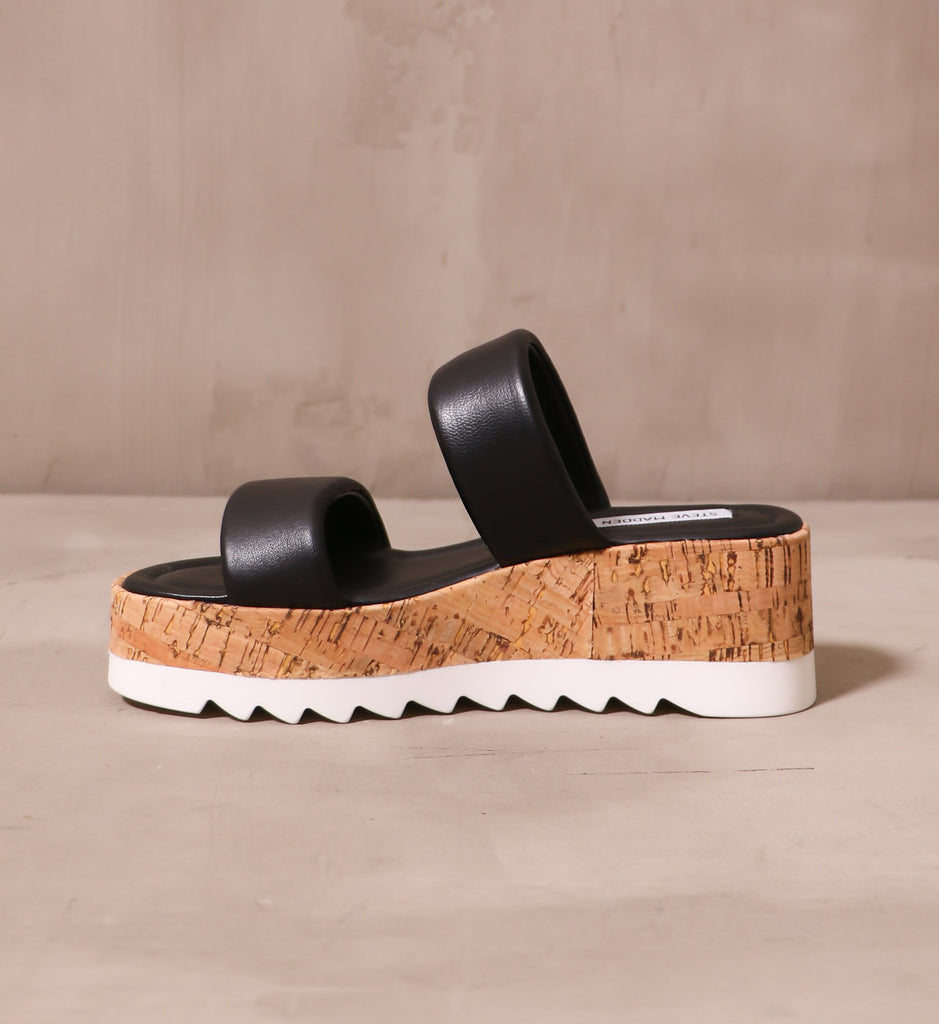 inner side of the sole purpose platform sandal with two puffy leather black straps on a faux cork sole