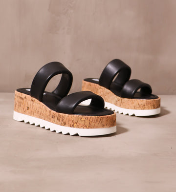 black puffy leather straps on cork sole with chunky white tread on the sole purpose platform sandals
