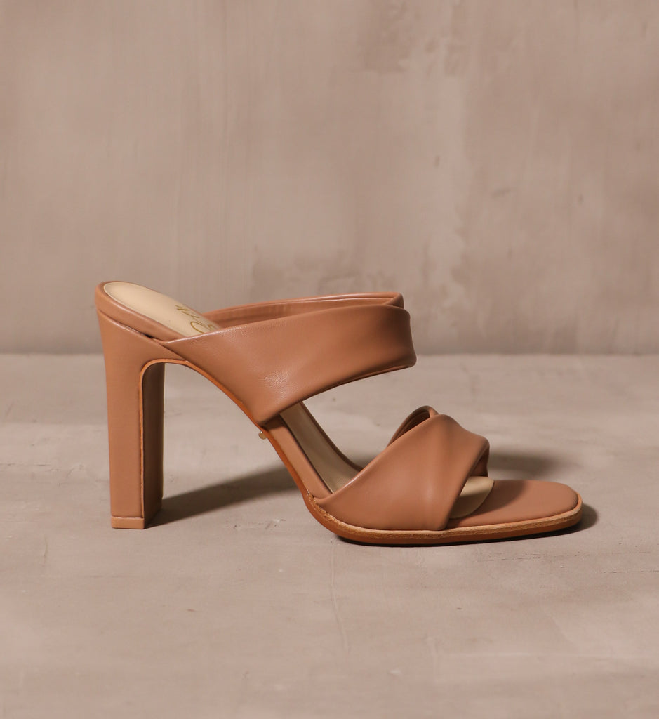 outer side of the tan leather state of luxe heel with rectangular block heel on cement background