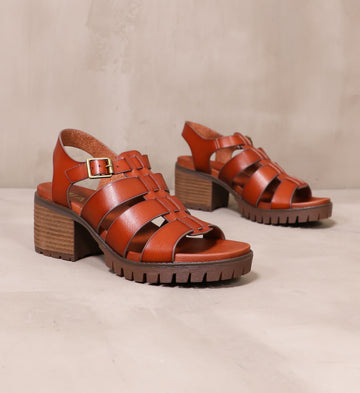 pair of brown leather strappy to cleat you sandals on cement background